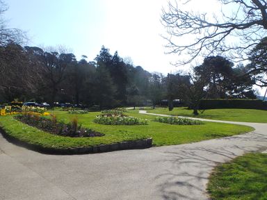 A park with flower beds paths and trees at Upper Deck in Truro