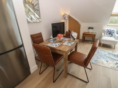 A dining area with a table and chairs at Upper Deck in Truro