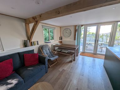 A living room with a sofa and a dining table at Roman Lodge in Osmington
