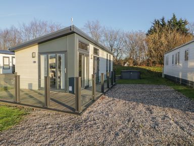 A modern single-story house with glass railing on the porch and gravel driveway at Yealand 36 in Tewitfield