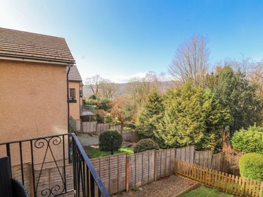 A garden view with trees and mountains at Lake View in Bowness-On-Windermere
