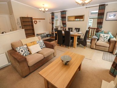 A living room with sofas dining table chairs and coffee table at 16 Heritage Park Heritage Park near Kilgetty