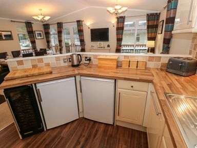 A kitchen with wooden countertops two small refrigerators a kettle toaster and a wine cooler at 16 Heritage Park Heritage Park near Kilgetty
