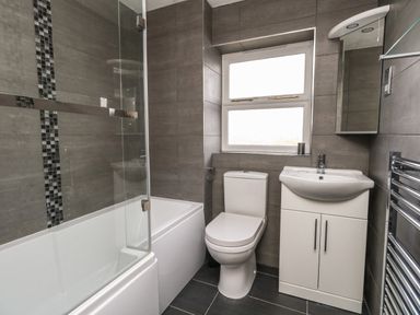 A bathroom with a bathtub shower combination toilet and sink cabinet at Amaranta Brewers Quay Harbour