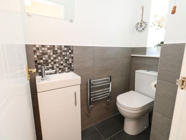 A small bathroom with a toilet sink and towel rail at Amaranta Brewers Quay Harbour