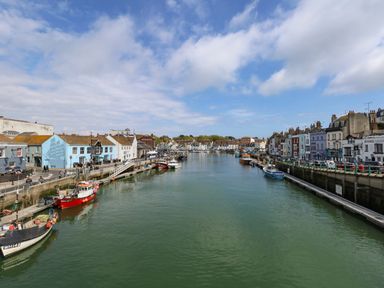 A harbour with boats docked along both sides and buildings lining the waterfront at Brewers Quay Harbour
