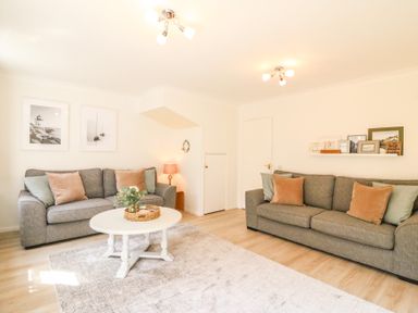 A living room with two grey sofas a white round coffee table and framed pictures on the walls at Amaranta Brewers Quay Harbour