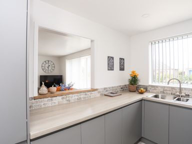A kitchen with a sink countertop window and decorative items at 31 Beach Road Morfa Bychan
