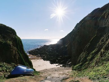 A path leading to the beach with a boat on the side at Cove Cottage in Porthgwarra