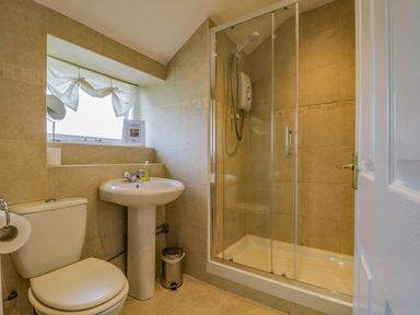 A bathroom with a toilet sink and shower with glass doors at The Old Mill in Keswick