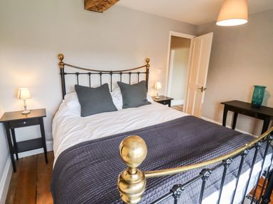 A bedroom with a double bed and bedside tables with lamps at Ley Mill Farm in Huntley