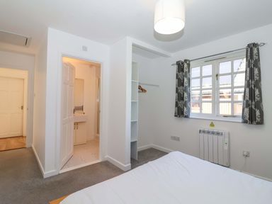 A bedroom with a bed and wardrobe at Bracken Cottage St Tudy
