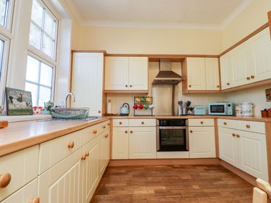 A kitchen with cream cabinets wooden handles wooden floor and countertop and appliances at Buzzards Rest in Stannington near Morpeth