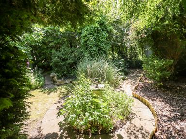 A garden with a circular paved area containing plants and a sundial at Buzzards Rest in Stannington near Morpeth