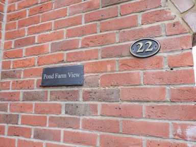 A brick wall with a number 22 plaque and a Pond Farm View nameplate at Pond Farm View in Hinderwell