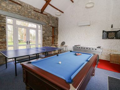 A game room with a pool table ping pong table foosball table and dartboard at Dinefwr Cottage in Golden Grove near Llandeilo