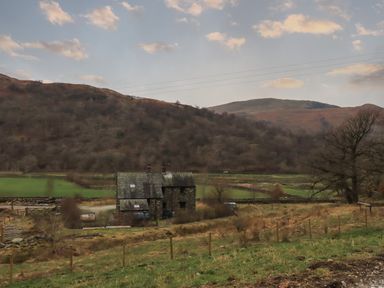 A stone house in a rural landscape with hills and trees at The Stag - Crossgate Luxury Glamping in Hartsop near Glenridding