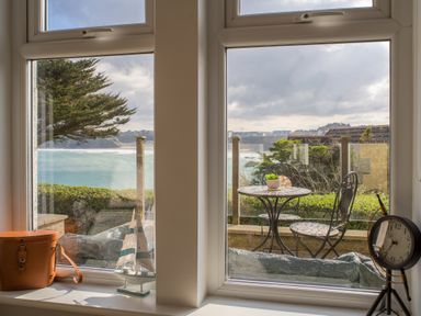 A window view with a table and chairs outside overlooking the sea at King Edward's View in Newquay