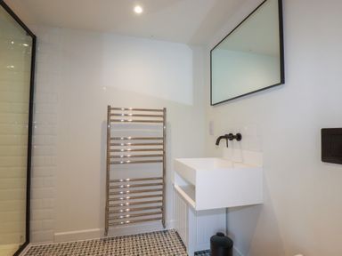 A bathroom with a towel rack sink and mirror at The Old Watermill in St Mabyn