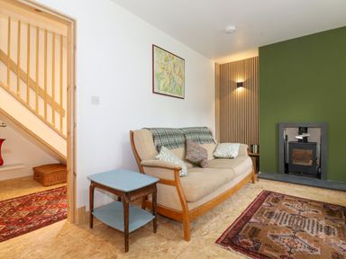 A living room with a sofa and a wood burning stove at Yamthwaite in Grizedale near Hawkshead