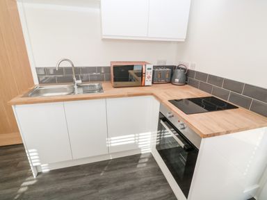 A kitchen with a sink microwave toaster kettle stove and oven at Perran Pearl A in Perranporth