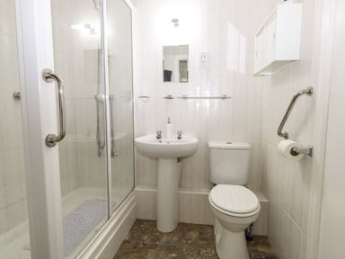 A bathroom with a shower enclosure sink and toilet at Beach Side in West Bay