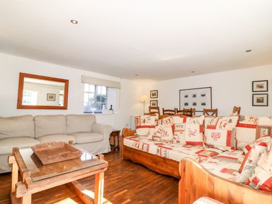 A living room with two sofas a wooden coffee table and framed pictures on walls at 1 The Lane in Chipping Norton