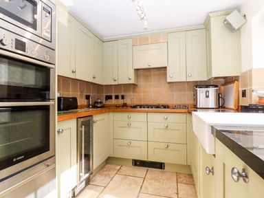 A kitchen with built in oven microwave wine cooler and a sink at 1 The Lane in Chipping Norton