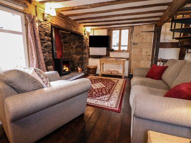A living room with two sofas a carpet and a fireplace at 18 Church Street in Llangollen
