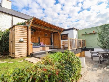 A garden with a wooden deck and seating at 18 Church Street, Llangollen