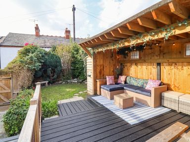 A garden with decking and a sofa at 18 Church Street Llangollen