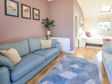 A living room with a sofa and a bed at The Garden Suite at Fiddler Hall Barn, Newby Bridge