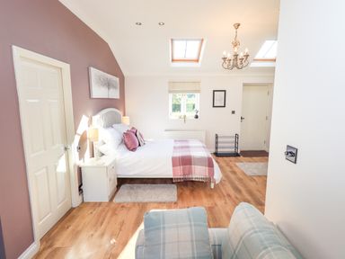 A bedroom with a bed and sofa at The Garden Suite at Fiddler Hall Barn Newby Bridge