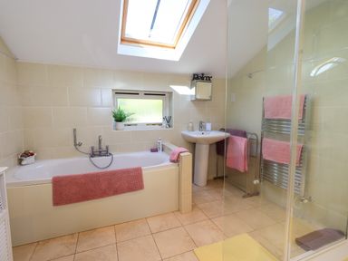 A bathroom featuring a bathtub, sink, and shower at The Garden Suite at Fiddler Hall Barn, Newby Bridge