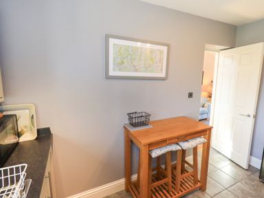 A kitchen with a table and map on the wall at The Garden Suite at Fiddler Hall Barn, Newby Bridge