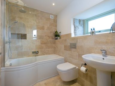 A bathroom with bathtub shower toilet sink and window at The Reading Room in Seworgan near Constantine