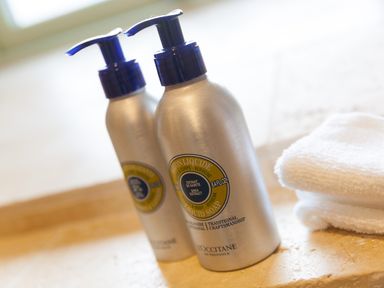 Two bottles of liquid soap with pumps and folded white towels on a counter at The Reading Room in Seworgan near Constantine