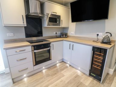 A kitchen with built in oven microwave toaster kettle and wine fridge at White Stones in Goadsbarrow near Roose