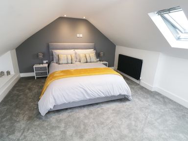 A bedroom with a double bed two bedside tables with lamps and a skylight window at White Stones in Goadsbarrow near Roose