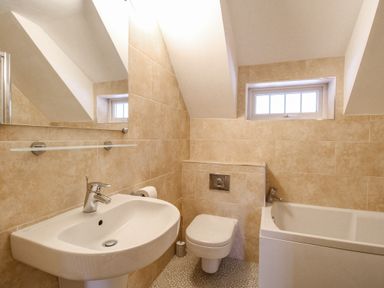 A bathroom with a sink toilet and bathtub at Cajun Cottage in West Lulworth
