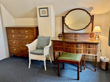 A bedroom with a dressing table and a chest of drawers at Cajun Cottage in West Lulworth
