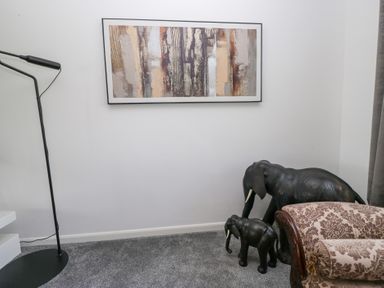 A living room with an elephant sculpture and a painting at Eildon Lodge in Gosforth