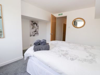 A bedroom with a bed and towels at Eildon Lodge in Gosforth