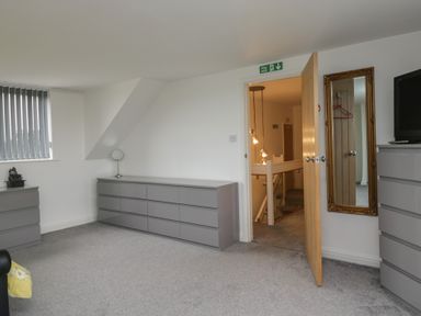A bedroom with chests of drawers and a mirror at Eildon Lodge in Gosforth
