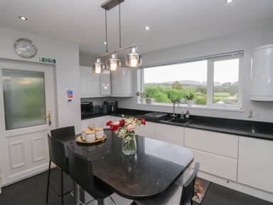 A kitchen with a table, chairs, and a window at Eildon Lodge in Gosforth