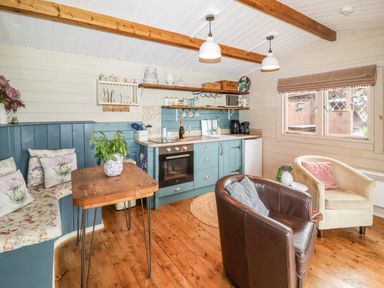 A small kitchen and seating area with wooden floors wooden beams and a window at Westfield Lodge in Terrington near Sheriff Hutton