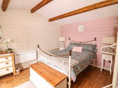 A bedroom with a bed a wooden chest a dresser and bedside tables at Westfield Lodge in Terrington near Sheriff Hutton