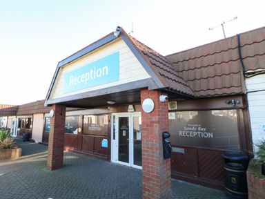 The entrance to Sandy Bay Reception with a covered porch supported by brick pillars and glass doors at Wansbeck View 2 in Ashington