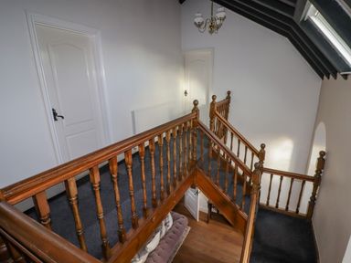 A staircase with wooden railings and two white doors at The Chapel in Dol-y-Gaer near Pontsticill