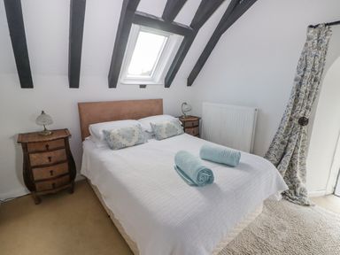 A bedroom with a double bed between two bedside tables under a skylight at The Chapel in Dol-y-Gaer near Pontsticill